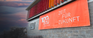 Blick auf das RAL Gebäude mit Jubiläumsbanner zu 100 Jahren RAL mit dem Slogan "Zeit für Zukunft"